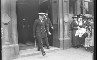 Sir Winston Churchill striding out from the entrance of Vickers in September 1915