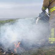 Firefighter extinguishes the open fire on Walney Island