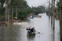 Residents paddle across a flooded area after heavy rain in Canoas, Rio Grande do Sul state, Brazil (Andre Penner/AP)