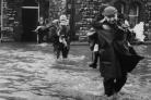 RIDE Youngsters cling on as they are given a lift to safety from floods at Dalton in November 1963.