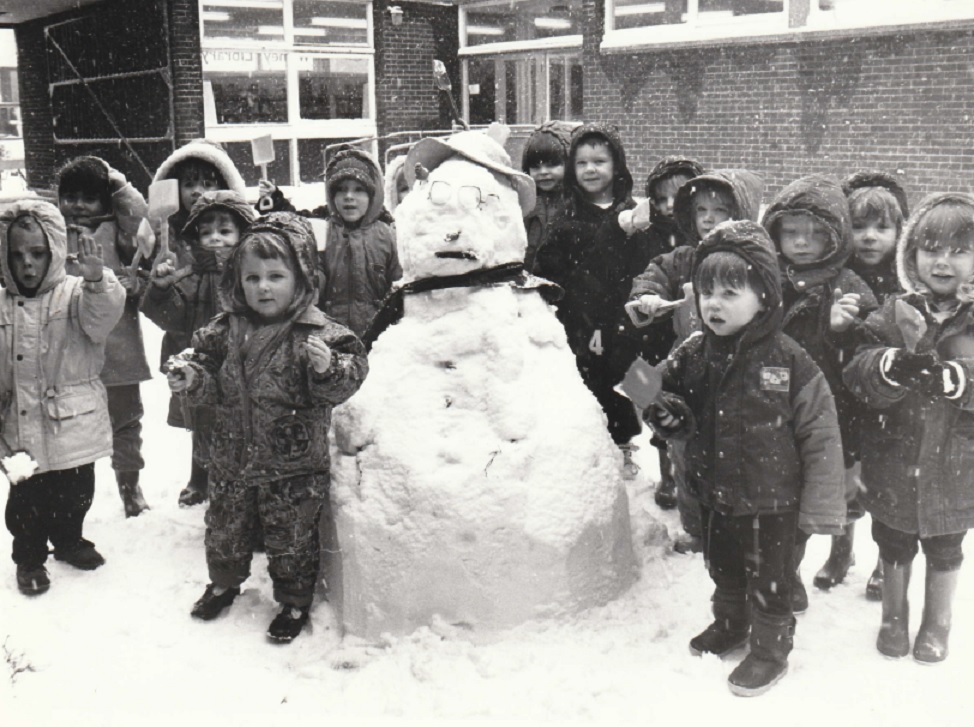 BUILD: A photograph from The Mail’s archives, believed to have been taken in the early 1990s, with three to- five-year-olds of Walney Central playgroup and their snowman