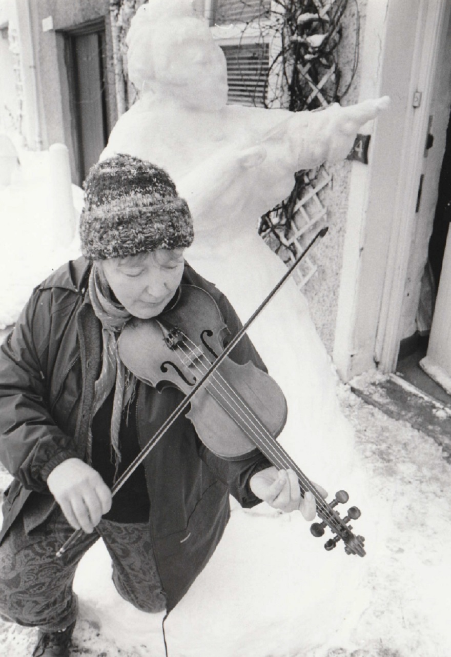 PLAYING: Gwenda Meredith serenades a snow sculpture in Market Street, Ulverston, in February 1996