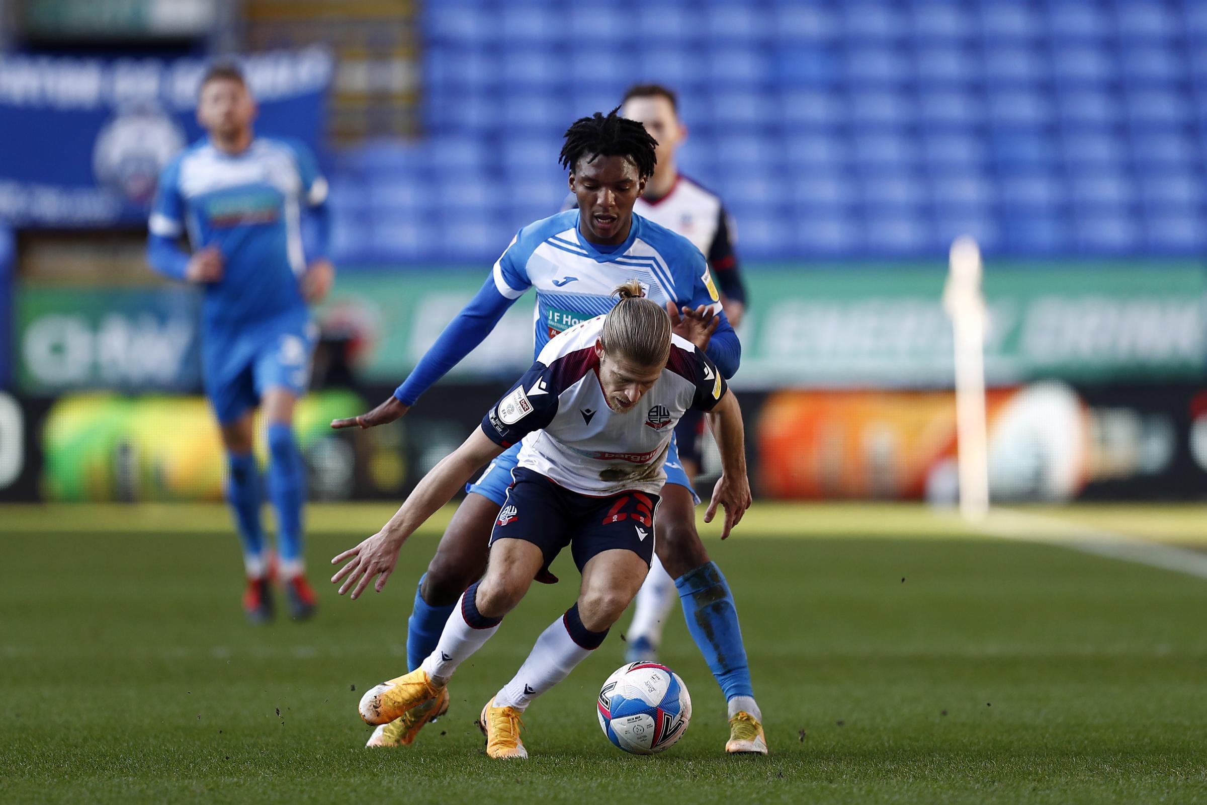 BOLTON, ENGLAND, FEB 27TH Barrows Kgosi Ntlhe challenges Boltons Lloyd Isgrove during the Sky Bet League 2 match between Bolton Wanderers and Barrow at the Reebok Stadium, Bolton on Saturday 27th February 2021. (Credit: Chris Donnelly | MI News)