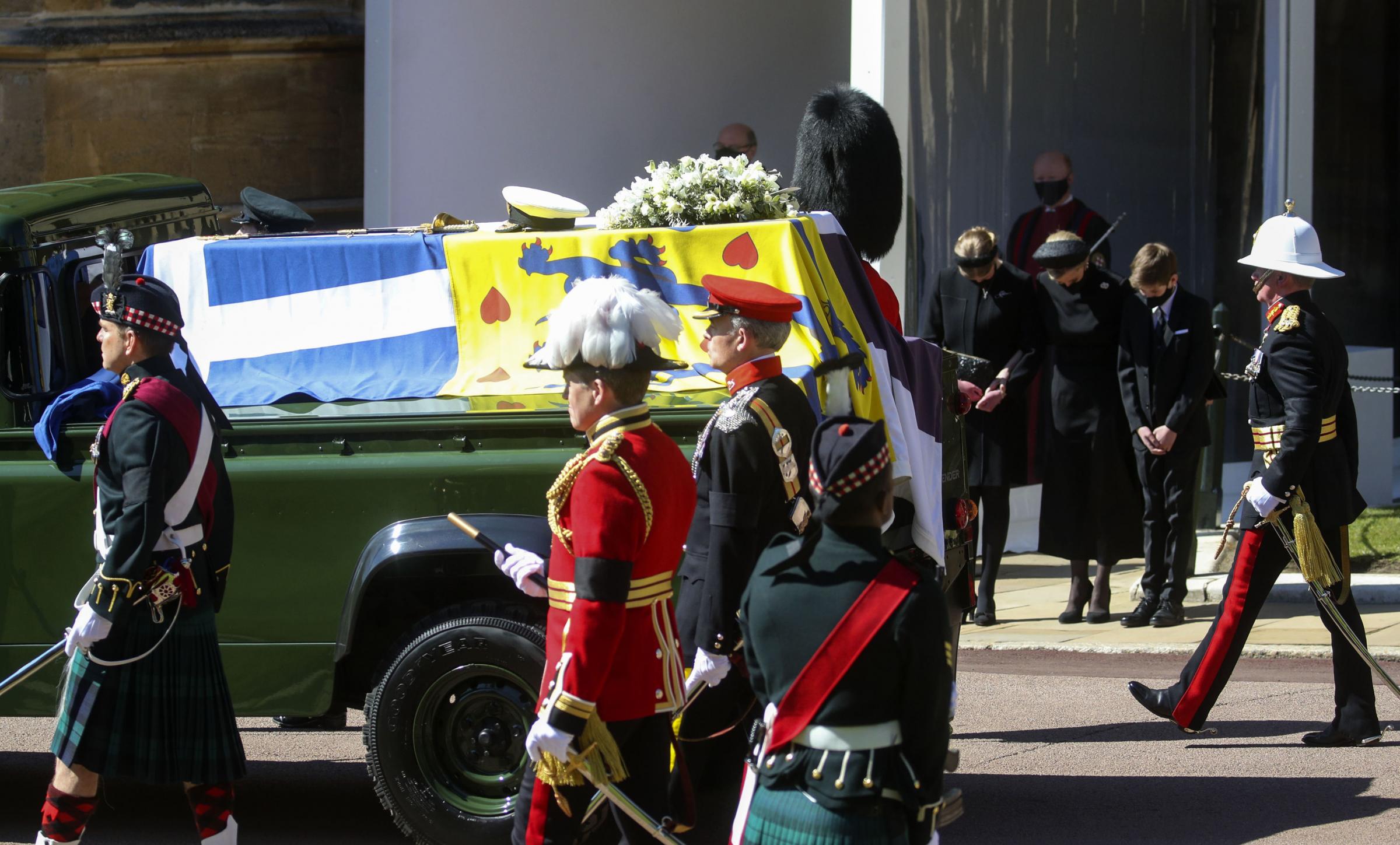 The Duke of Edinburghs coffin, covered with his Personal Standard, is carried on the purpose built Land Rover Defender drives past (left to right) Lady Louise Windsor, the Countess of Wessex and James, Viscount Severn with heads bowed, at the Galilee
