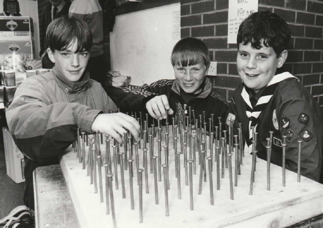 GAMES: Richard Morgan, 12, (right), Kevin Dyer, 13, and Nick Moody 13, try to pick the winning nail in a game at a gala to mark the 75th anniversary of the 8th Barrow St Mary’s Scout Group in 1995