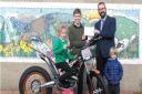 Broughton rider James Postlethwaite presents a cheque for £500  from the LMTA to acting Headmaster Mr Knaggs.