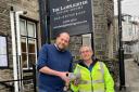 James Tasker, the owner of the Lamplighter  and Gary the Town Steward shaking hands whilst handing over the wildlife trail camera