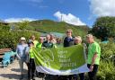 Staff and volunteers celebrate with the Green Flag award 2023/24 banner