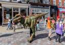 A dinosaur patrolling the street