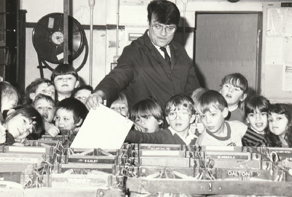 POST: Postman John Mease had plenty of help during a visit by Abbotsmead Infant School pupils to the sorting office in Barrow in 1994