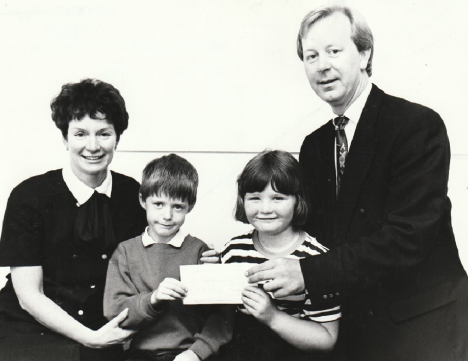 SCHOOL: Production director Doug Mackay presents Â£250 from The Mail’s charitable trust to Abbotsmead Infant School pupils Michael Anderson and Annie Catherine Smith with headteacher Yvonne Waring in 1993. The money would help fund a