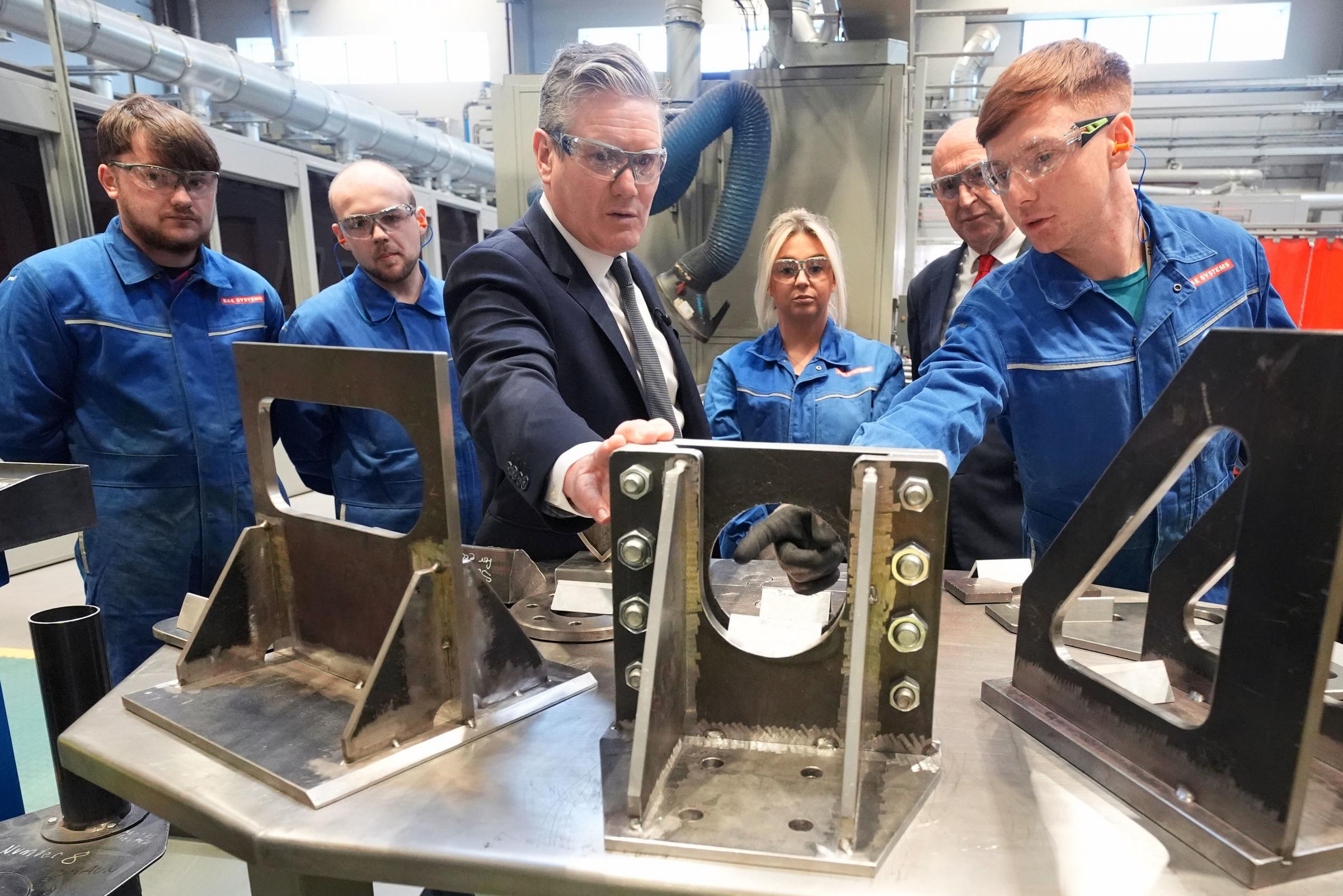 Labour Party leader Sir Keir Starmer talking to workers whilst looking at metalwork during a campaign visit to BAE Systems in Barrow-in-Furness, Cumbria. The Labour leader has said the UKs nuclear deterrent is the bedrock of his plan to keep