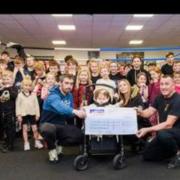 Barrow Amateur Boxing Club (Barrow ABC) pictured with Mia and her family holding the cheque