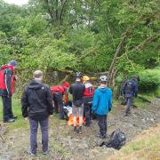 Coniston Mountain Rescue team attending to the injured mountain biked in Spring Wood