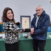 Town mayor Michelle Scrogham presenting Ken Barratt with his certificate of recognition.