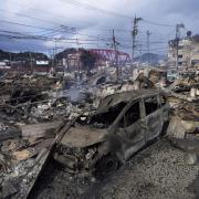 A burnt car and debris are seen at a marketplace after a fire following a strong earthquake in Wajima, Ishikawa prefecture, Japan (Kyodo News via AP)