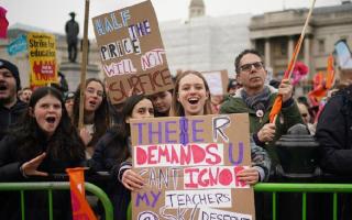 A young girl holds a banner in support of her teachers during strike action in London on March 15